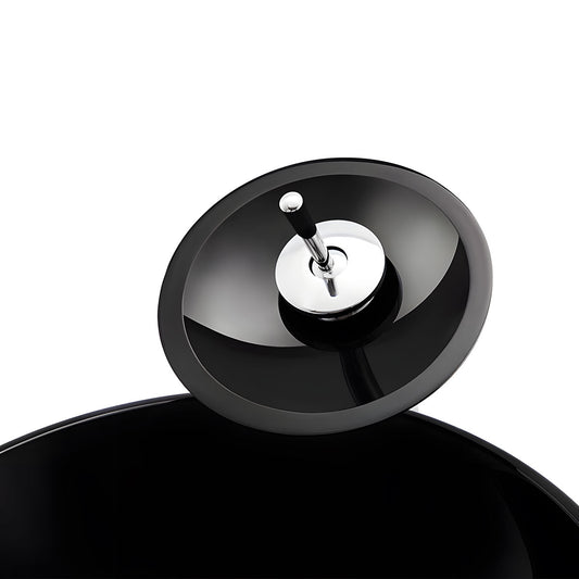 Close-up macro shot of high-gloss smooth black surface on round tempered glass basin, showing scratch-resistant reflective texture and curved rim detail