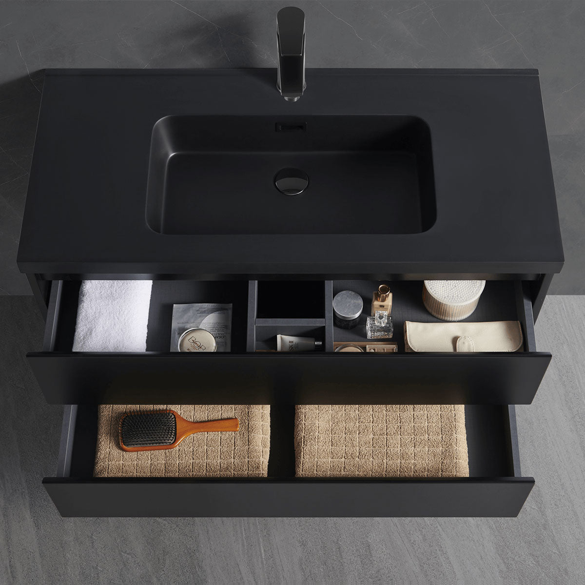 Top-down angle matte black integrated sink vanity with open drawers displaying practical bathroom storage layout
