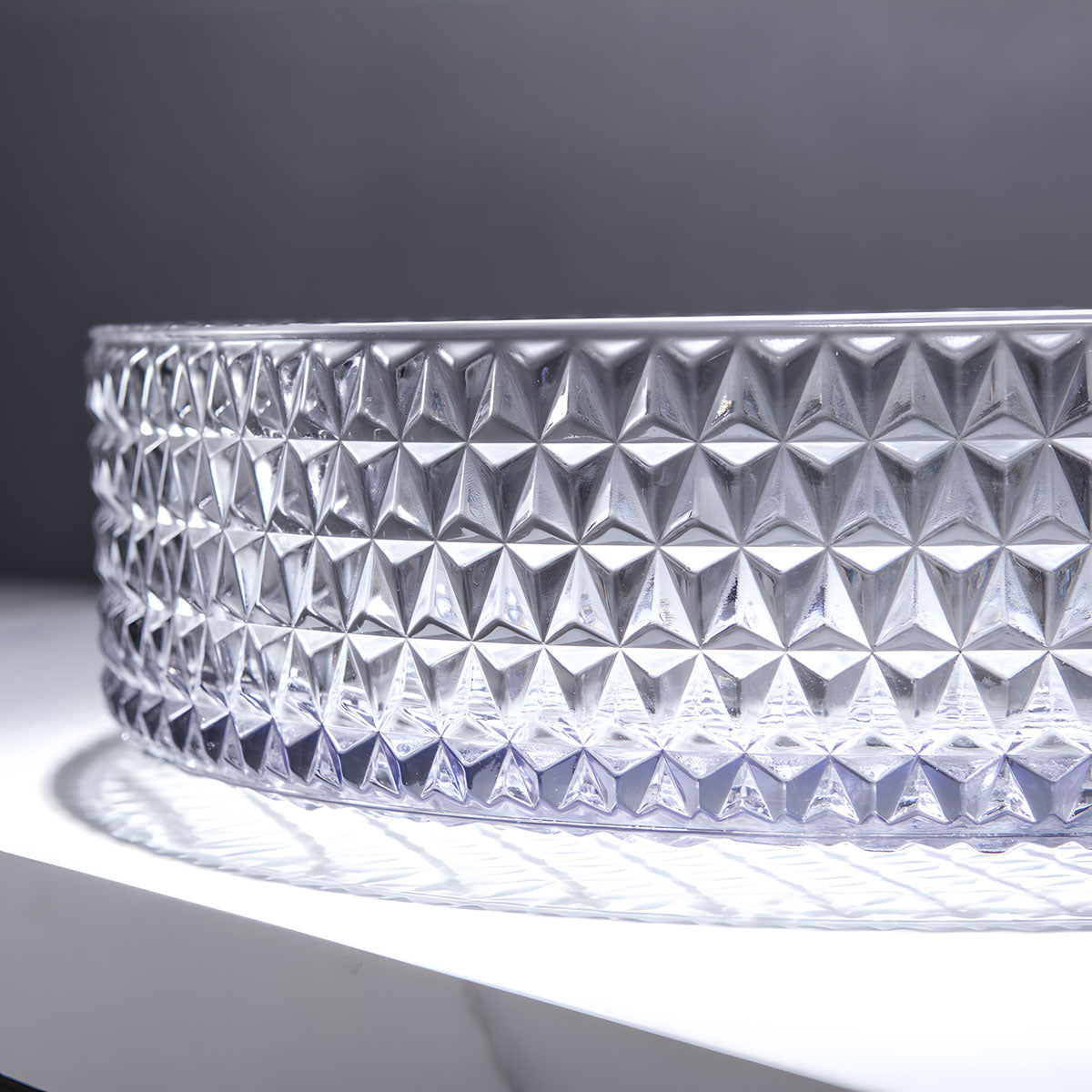 Close-up shot of diamond textured surface on clear round tempered glass bathroom vessel sink, crystal embossed craft detail